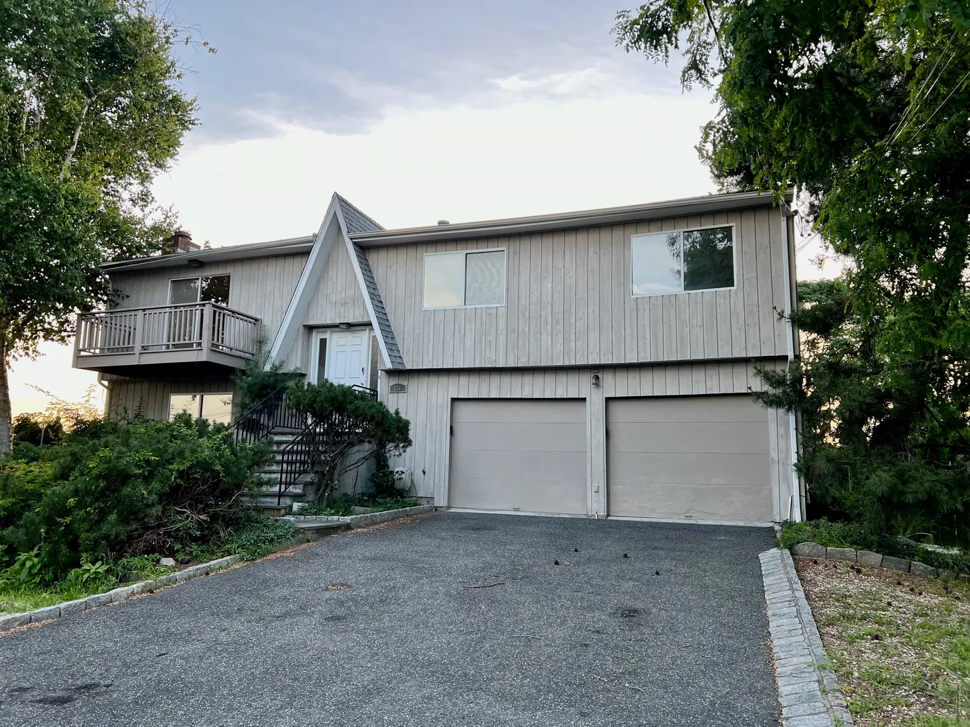 1970s raised ranch house with grey siding